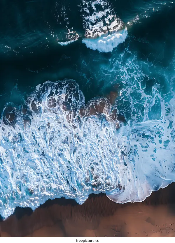 Aerial View of Ocean Waves Crashing on Sandy Beach