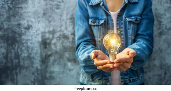 A woman holding a glowing light bulb in her hands
