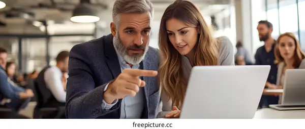 Business Partners Analyzing Data On Laptop