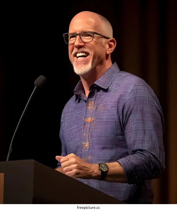 Smiling Man Speaking at a Podium with Microphone