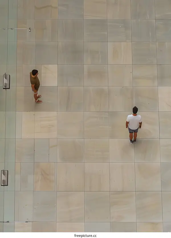Two Men Standing on Tile Floor From Above