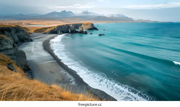 Iceland Black Sand Beach with Turquoise Ocean and Mountains in Background