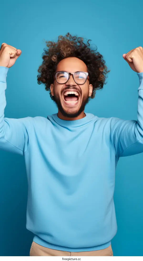 Young african american man celebrating success with raised fists