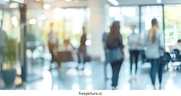 Blurred image of people walking in an office