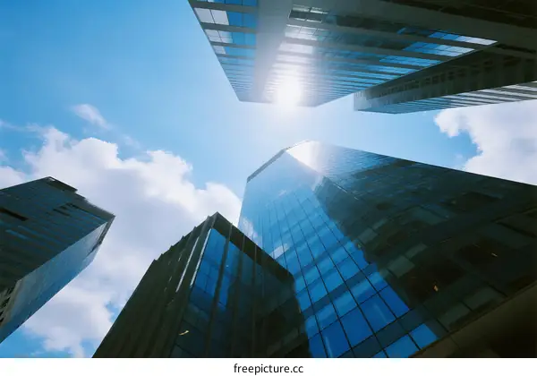 Looking up at modern skyscrapers under a clear blue sky