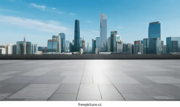 Modern city skyline with empty concrete ground under clear blue sky