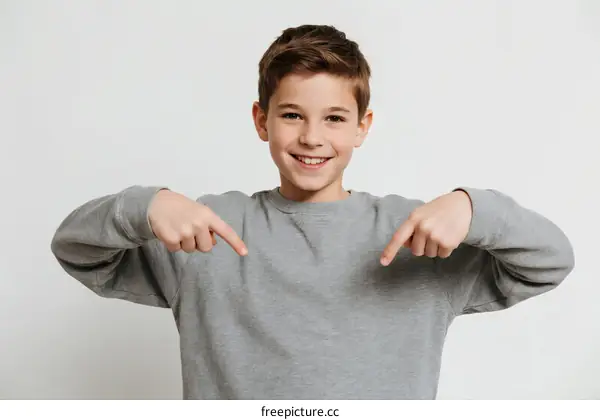 Young boy pointing at himself with a cheerful expression
