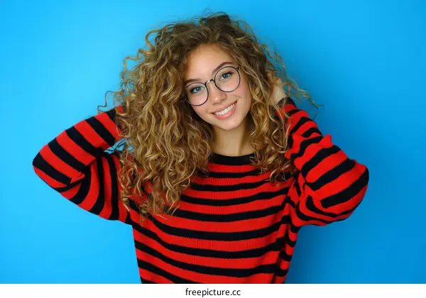 Smiling Woman with Curly Hair in a Striped Sweater