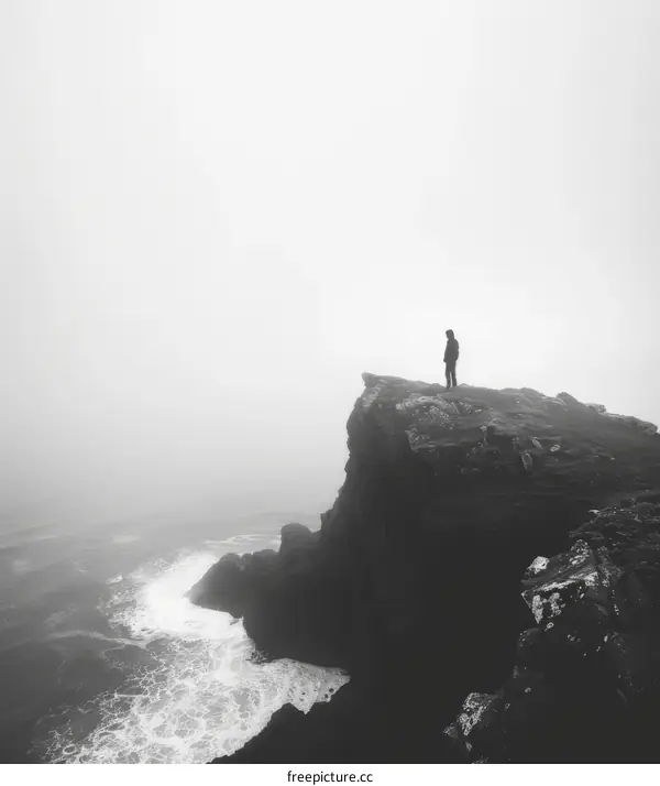 Man standing alone on a cliff overlooking a vast ocean