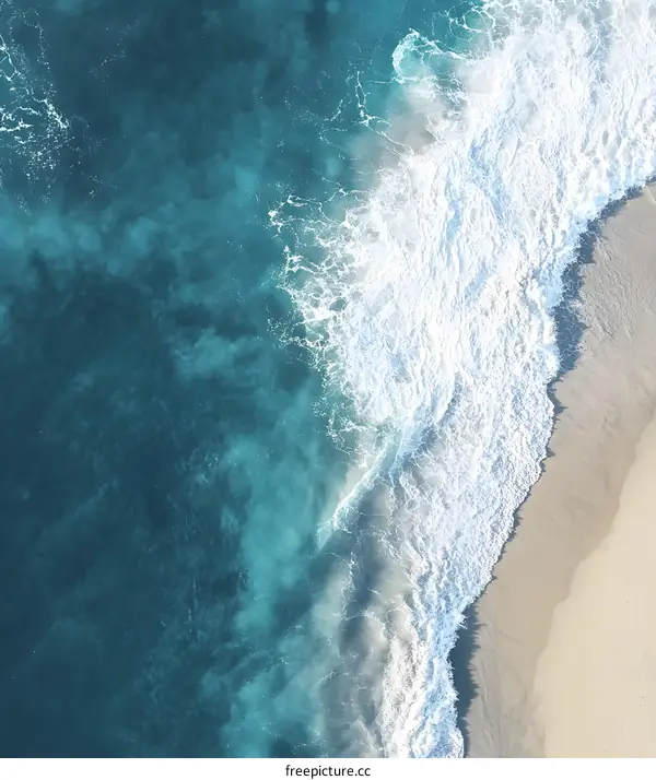 Aerial View of Ocean Waves Crashing on Sandy Beach
