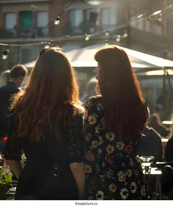 Two Women in Dresses Talking in a Outdoor Setting