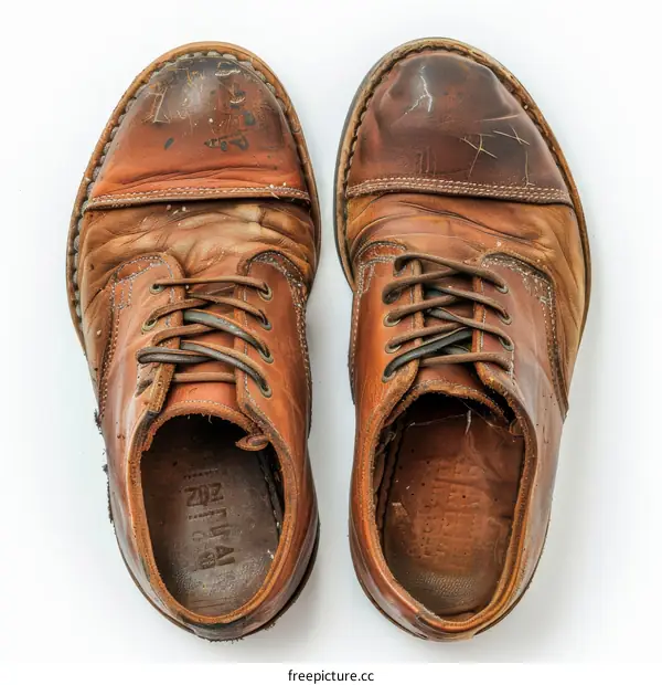 A pair of worn-out brown leather shoes