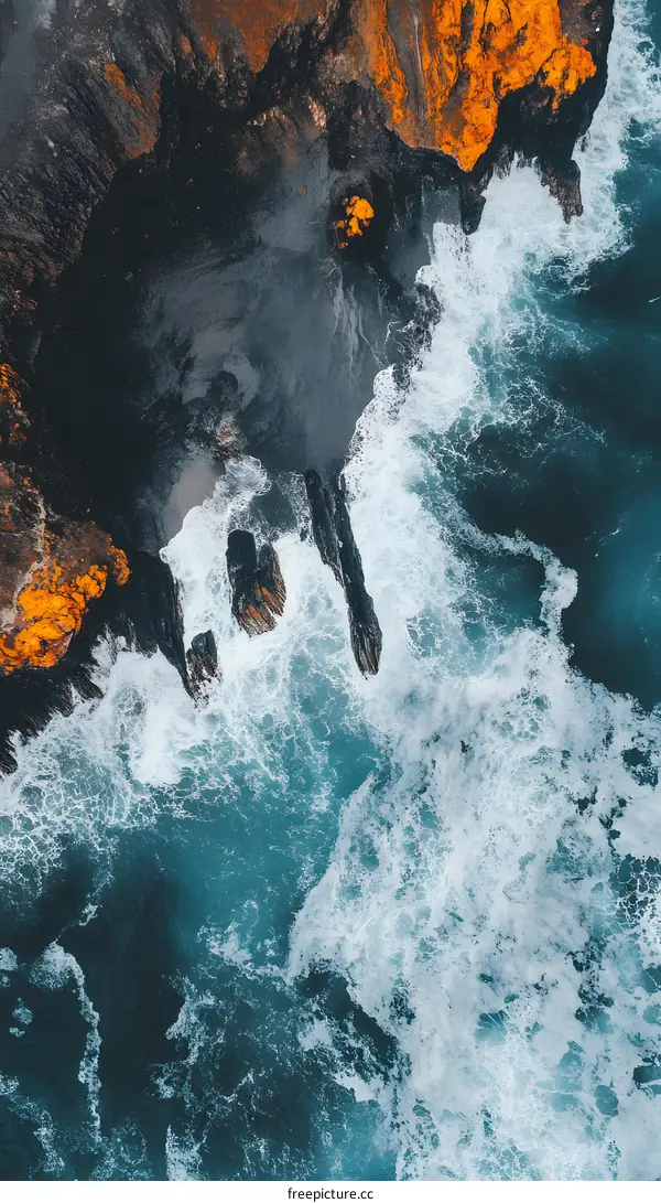 Aerial View of Ocean Waves Crashing Against Rocky Coastline