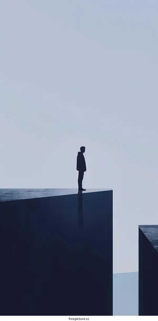 Silhouette of a Man Standing on a Cliff Edge