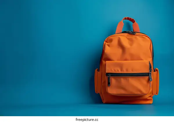 Orange Backpack on Blue Background: Stylish & Minimalist