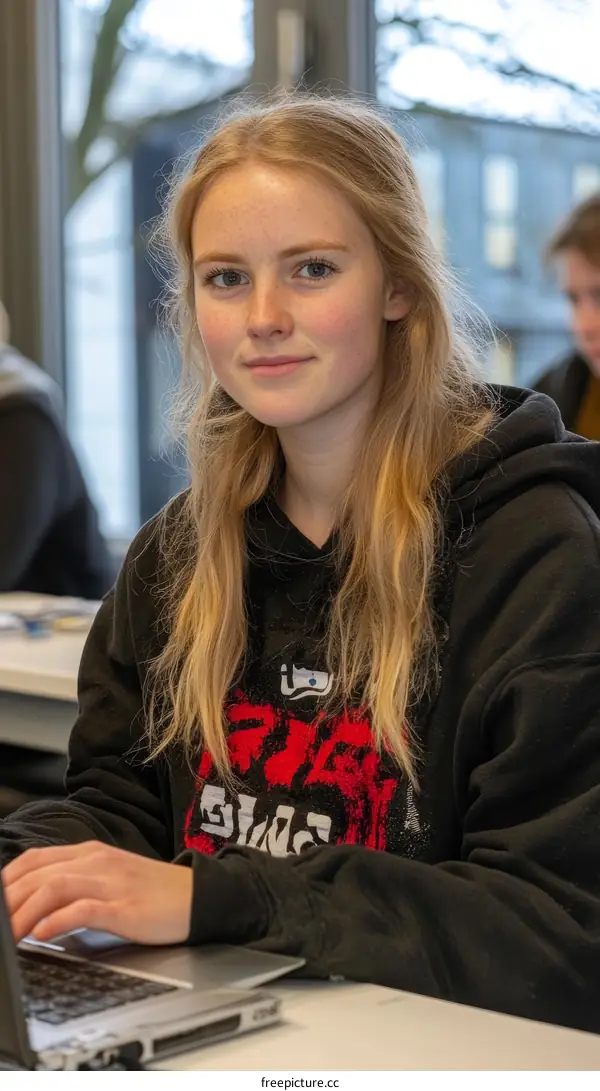 Young Woman Working on Laptop in Classroom Setting
