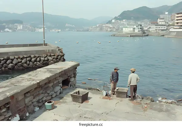 Two Men Standing on a Concrete Pier by the Sea in Japan