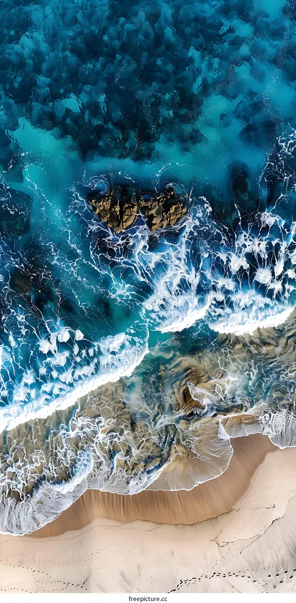 Aerial View of Ocean Waves Crashing on Sandy Beach