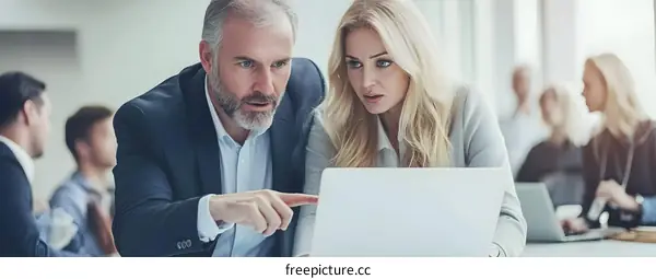 Business Colleagues Looking At Laptop Screen In Office