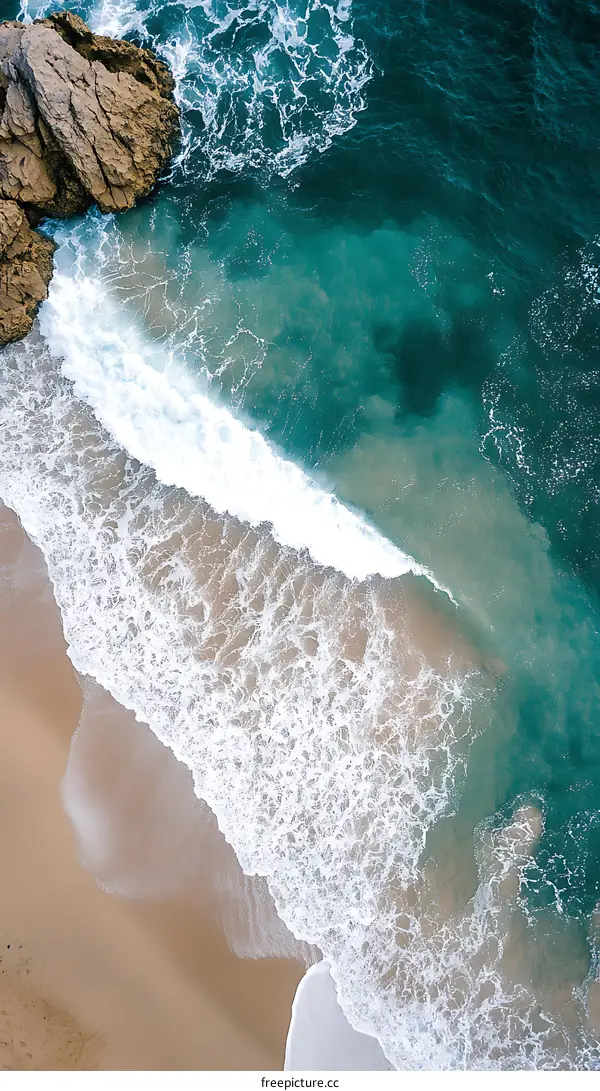 Aerial View of Ocean Waves Crashing on Sandy Beach