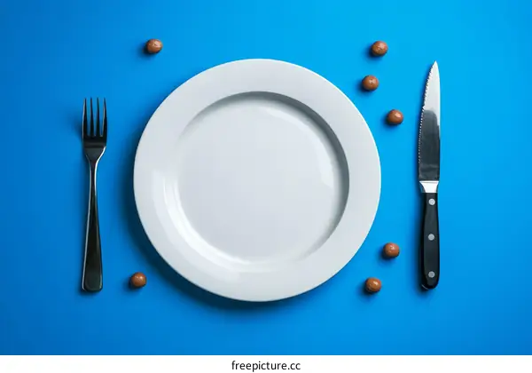 Empty Plate with Utensils on a Blue Background