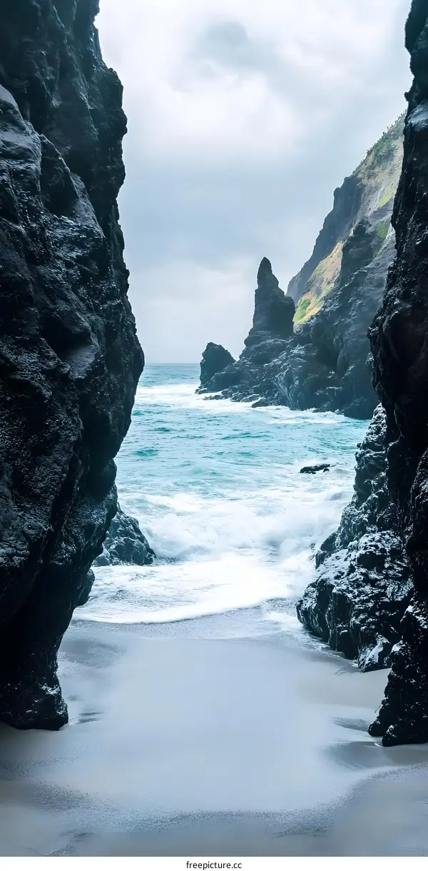 Dark Volcanic Rocks Framing a Sandy Beach and Turquoise Ocean