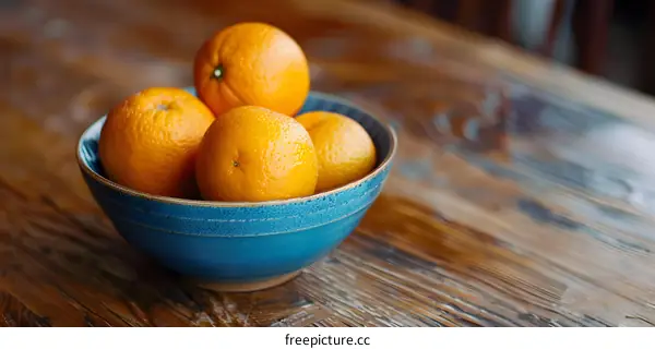Blue Bowl with Oranges on Wooden Table