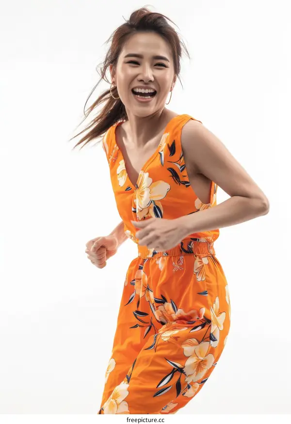 Cheerful Asian woman in orange floral jumpsuit