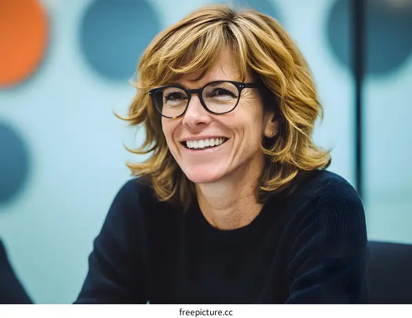 Smiling Woman in Glasses with Blue and Orange Background