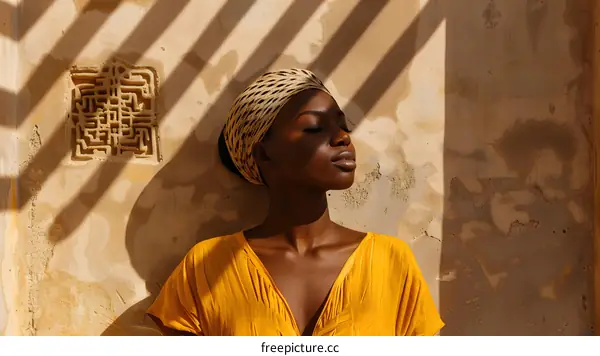 African Woman In Yellow Dress Standing With Eyes Closed In Sunlight