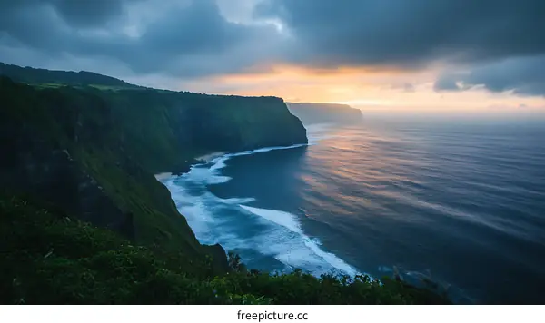 Dramatic Cliffside Overlooking a Vast Ocean at Sunset