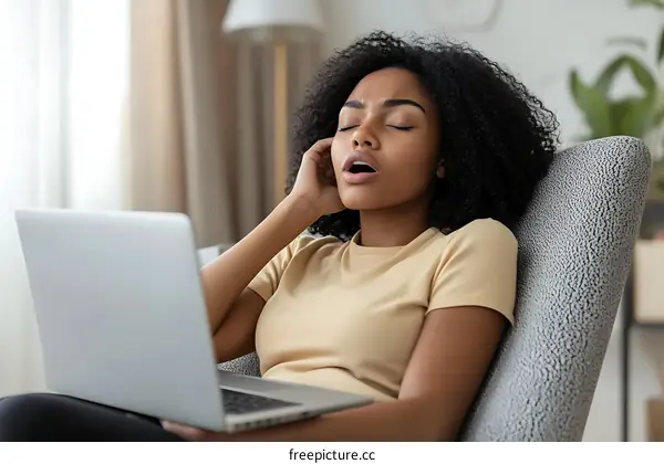 Woman Tiredly Working On Laptop At Home