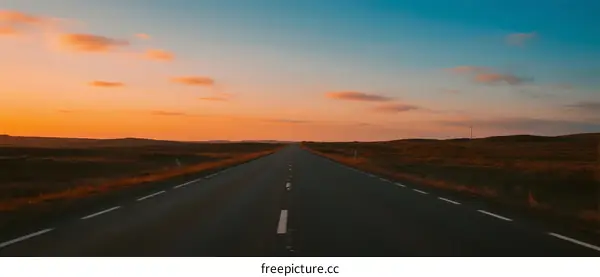 Long straight road under a beautiful sunset sky