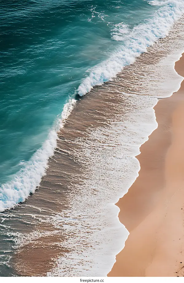 Aerial View of Ocean Waves Crashing on Sandy Beach