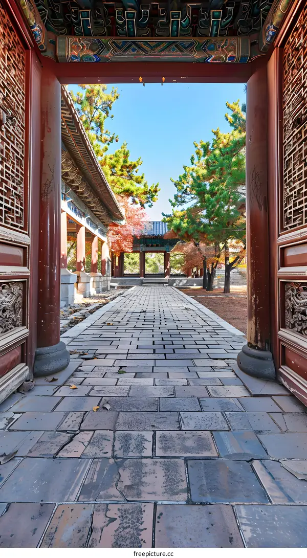 Ancient Chinese Architecture with a Brick Pathway Leading to a Courtyard with Trees