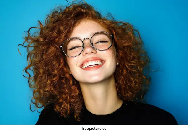 Happy Woman with Curly Red Hair and Glasses