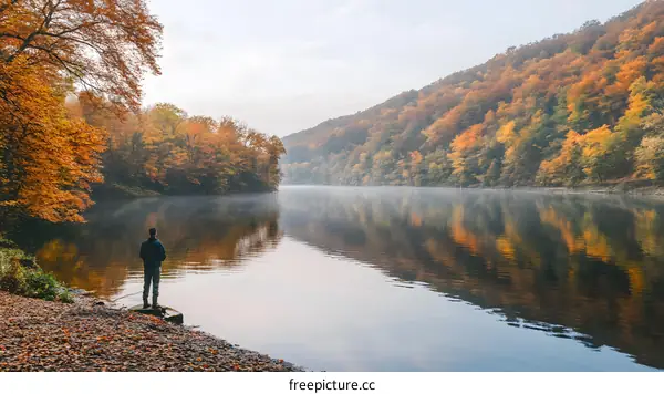 Man Standing by Autumn River