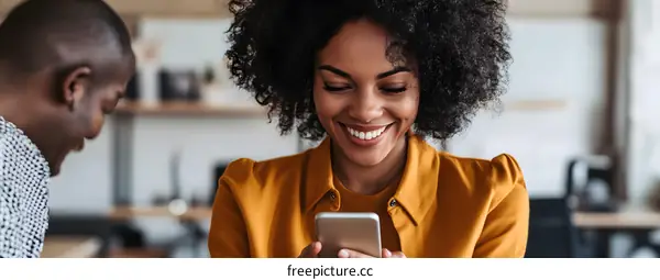 Smiling Woman Using Her Smartphone in Office Setting