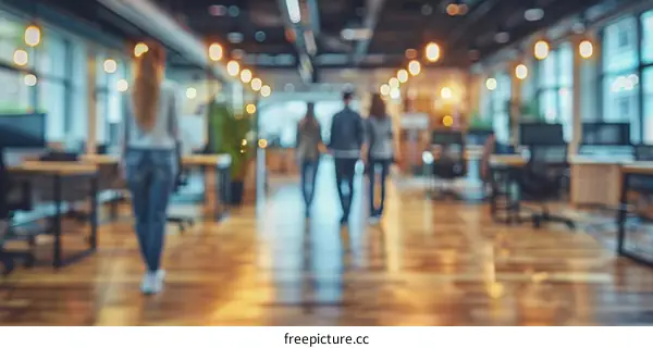Blurred image of people walking in an office
