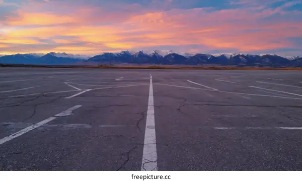 Empty Parking Lot at Sunrise with Snowy Mountains