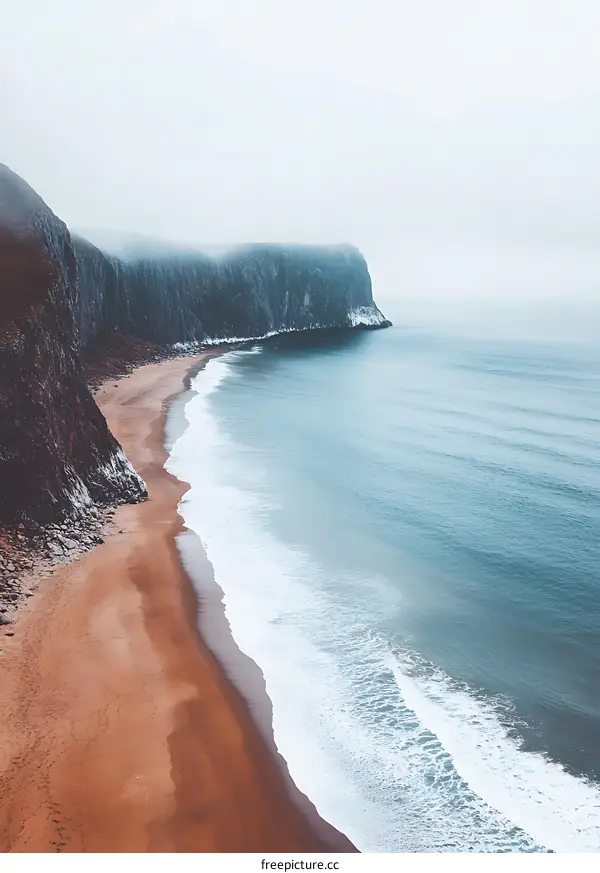 Aerial View of Sandy Beach and Rocky Cliffs with Fog