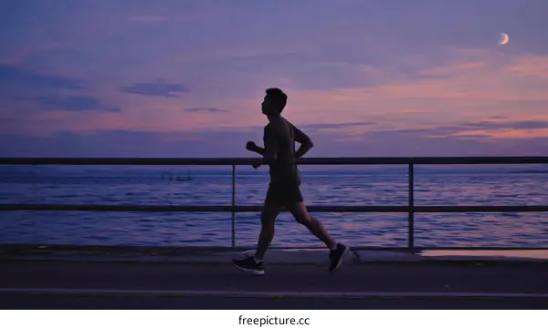 Silhouette of a person running along the seaside at sunset