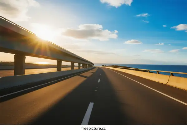 Sunlit highway with bridge and clear blue sky