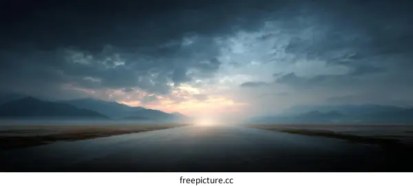 Empty Asphalt Road Towards Sunrise Through Misty Mountains