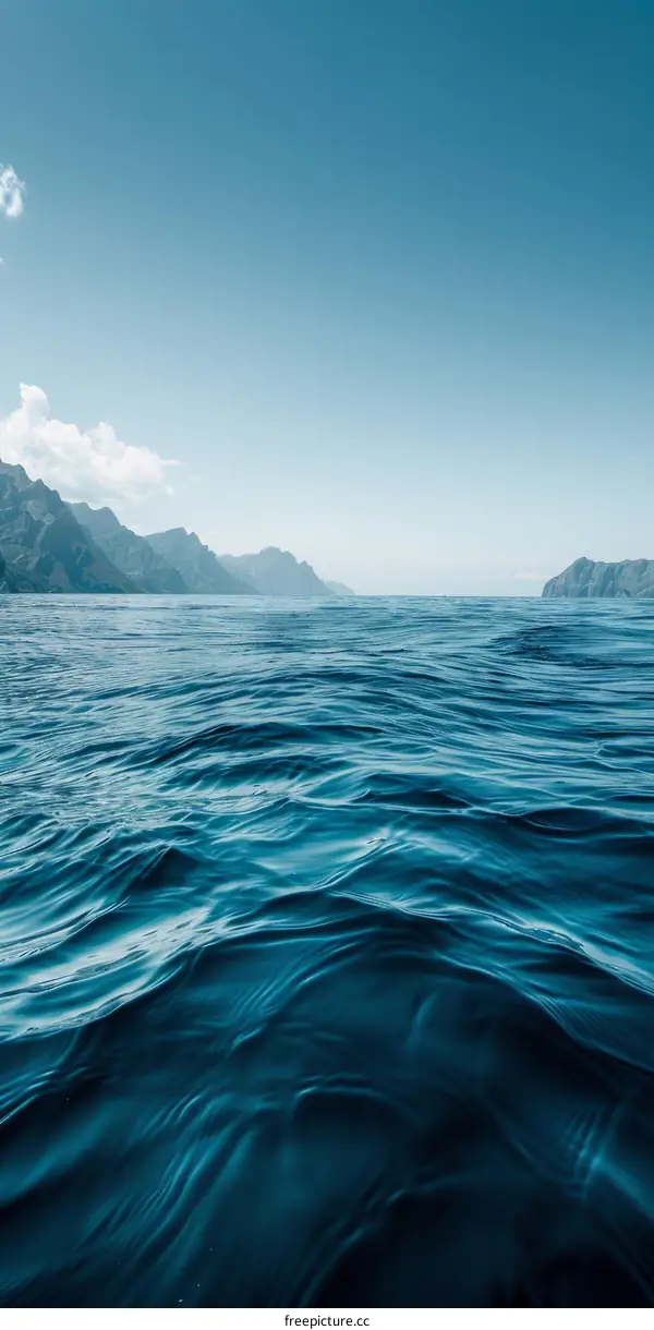 Deep blue sea surface with mountain range in the distance