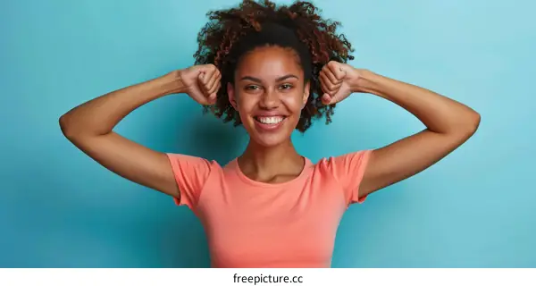 Happy African American woman celebrating success with raised arms