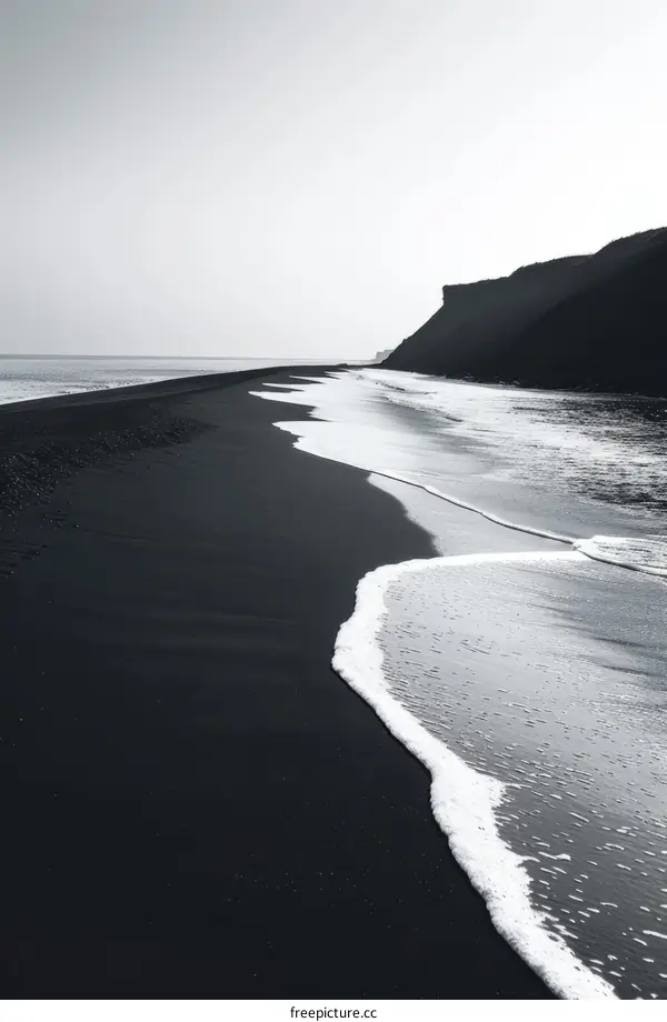 Black sand beach with a small wave coming in