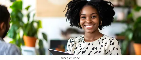 Smiling Black Woman Holding a Tablet in a Home Office