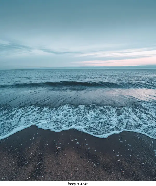 gentle waves lapping the sandy beach at dusk