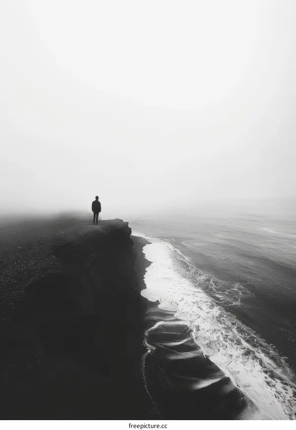 Man standing alone on a cliff overlooking a vast body of water